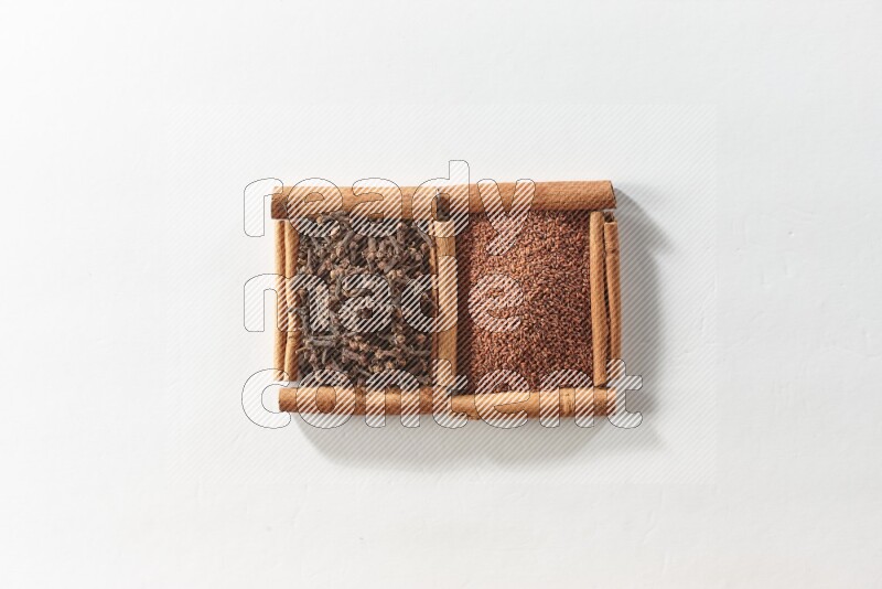 2 squares of cinnamon sticks full of garden cress and cloves on white flooring