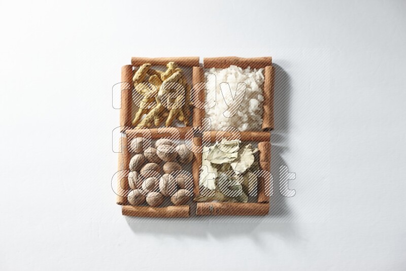 4 squares of cinnamon sticks full of salt, bay laurel, nutmeg, turmeric on white flooring