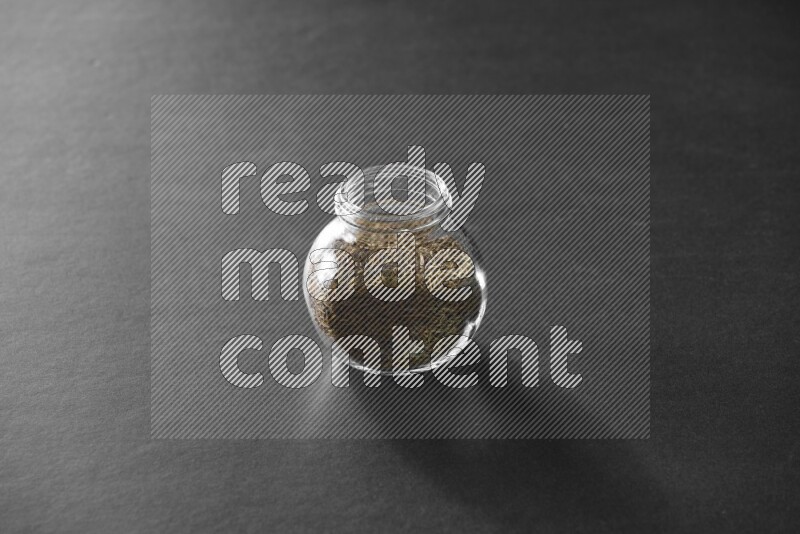 كمون في وعاء زجاجي علي خلفية سوداء