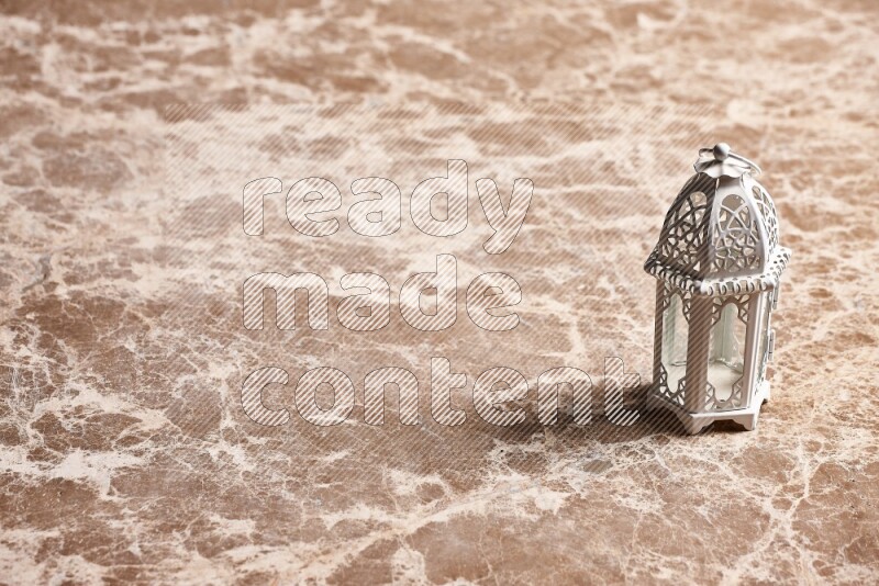 A candle lantern on beige marble background