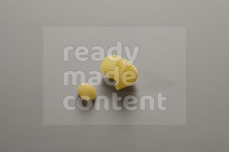 Shells pasta with other types of pasta on grey background