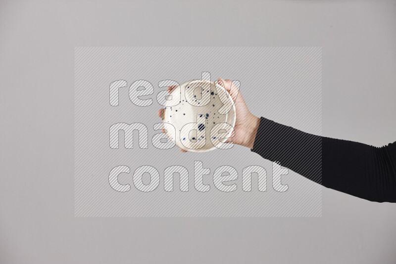 A woman in black abaya holding different pottery essentials in different positions