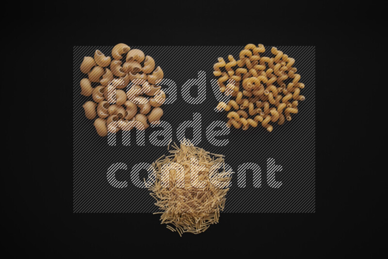 Different pasta types in bunches on black background