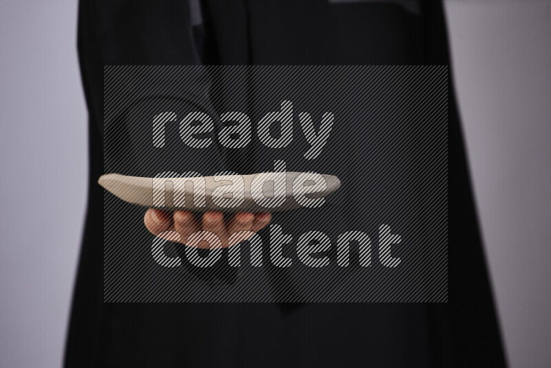 امرأة ترتدي عباءة سوداء تحمل أدوات فخارية مختلفة في أوضاع متعددة