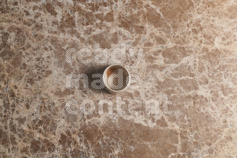 A multicolored pottery bowl on beige marble background