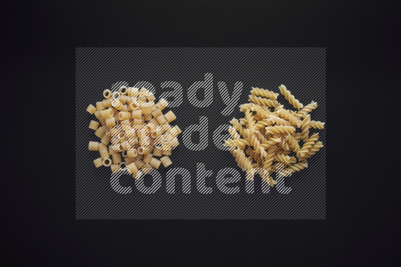Different pasta types in bunches on black background