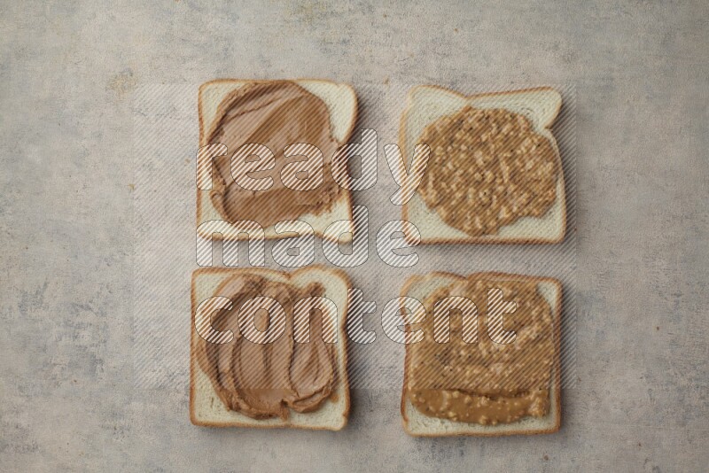 Creamy and Crunchy peanut butter on a white toast on a light blue textured background