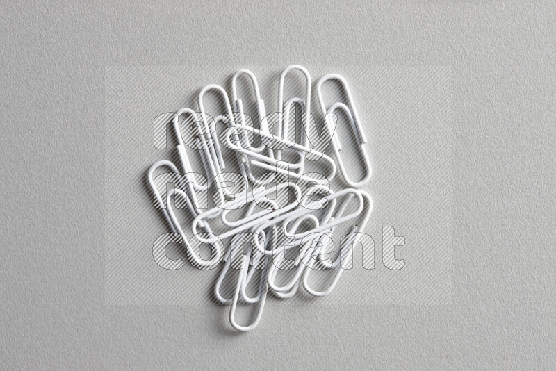 White paper clips isolated on a grey background