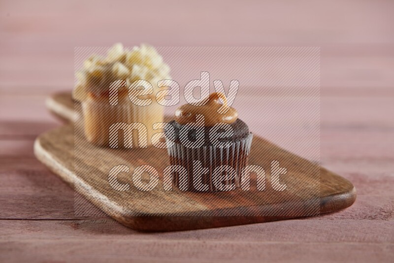 Chocolate mini cupcake topped with peanut butter on a wooden board