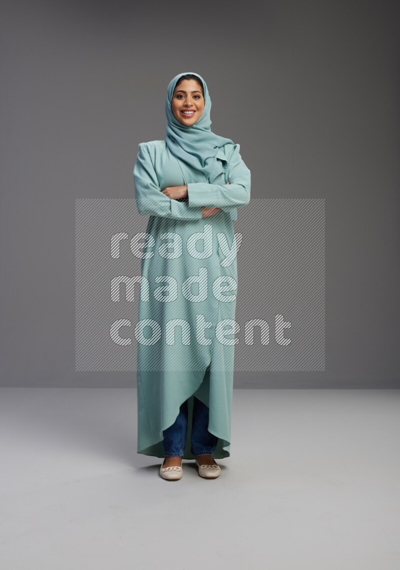 Saudi Woman wearing Abaya standing with crossed arms on Gray background
