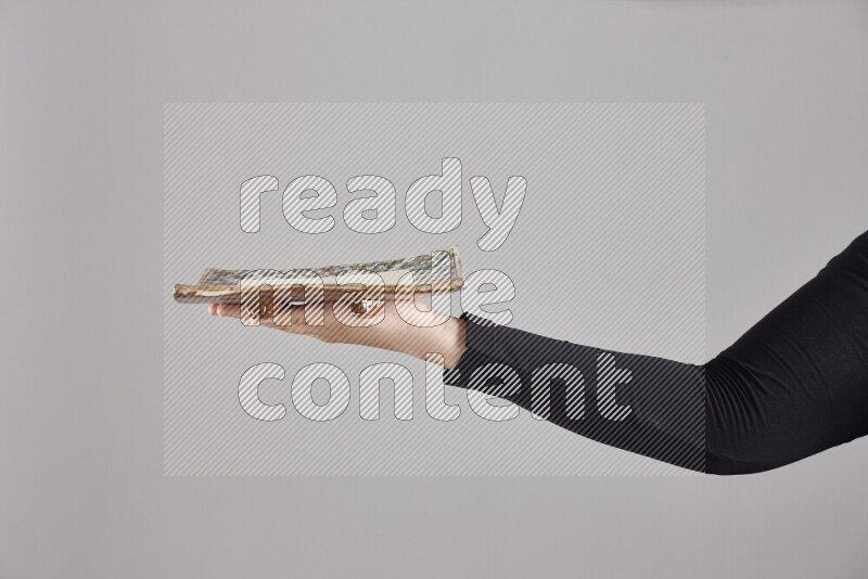 A woman in black abaya holding different pottery essentials in different positions