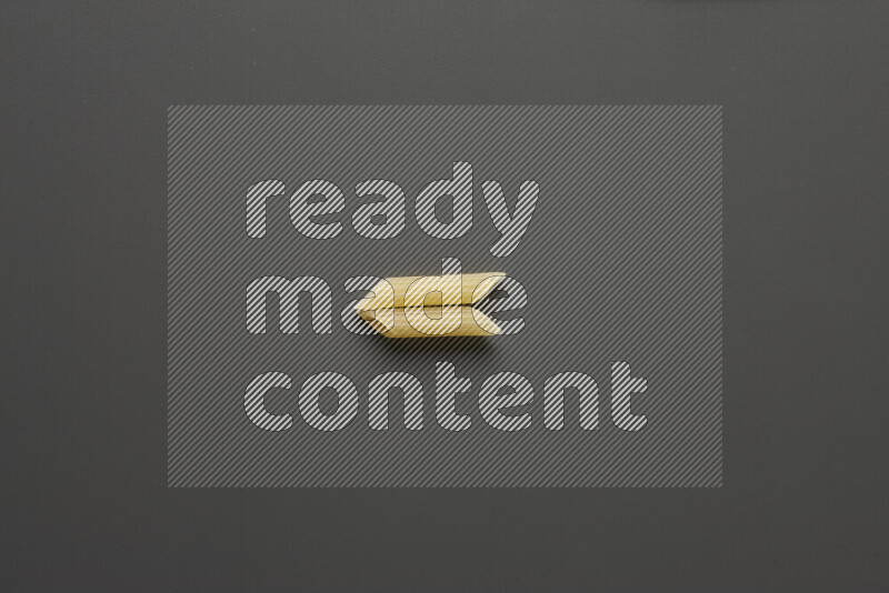 Mini penne pasta on grey background