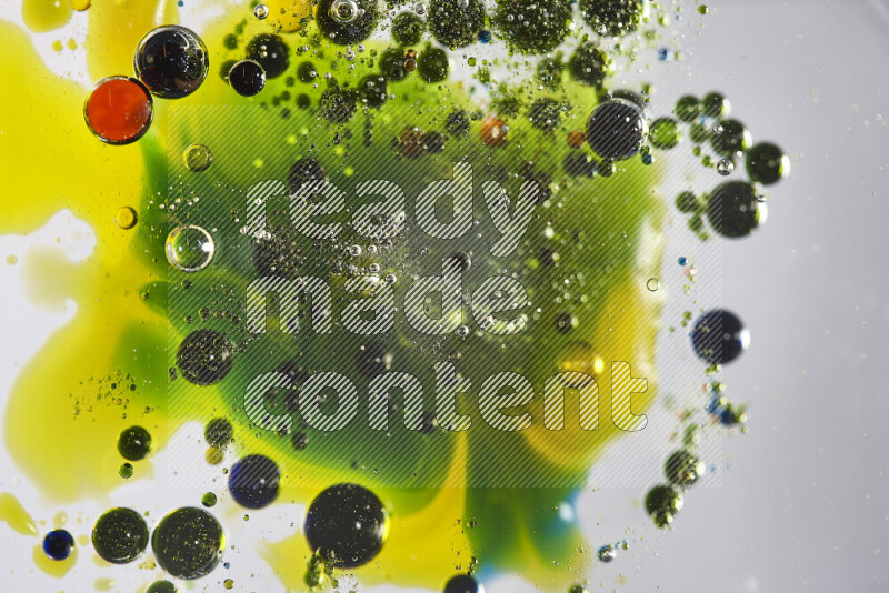 Close-ups of abstract red, blue, yellow and green watercolor drops on oil Surface on white background