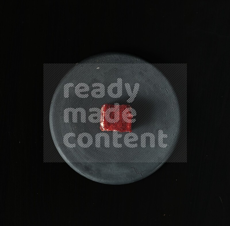 تشكيلة من الحلويات في طبق فخاري أسود على خلفية سوداء