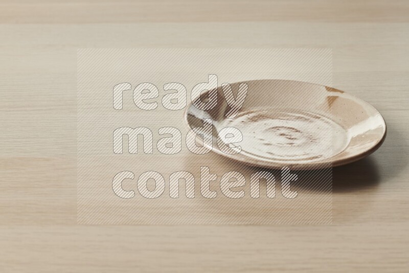A multicolored pottery plate on light wooden background