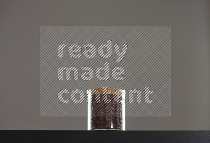 Red kidney beans in a glass jar on black background