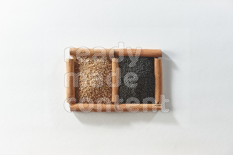 2 squares of cinnamon sticks full of mustard seeds and black seeds on white flooring
