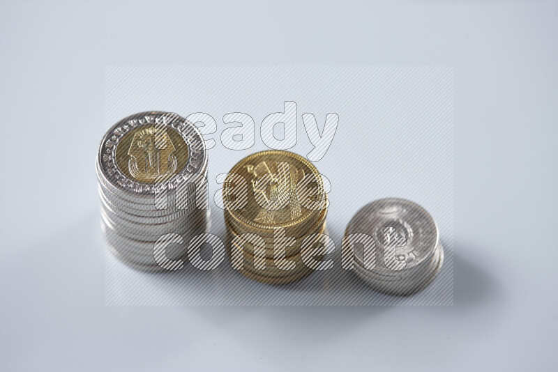 A close-up of scattered mixed Egyptian coins such as One pound, 50 and 25 piasters on grey background