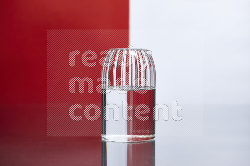The image features a clear glassware filled with water, set against white and red background