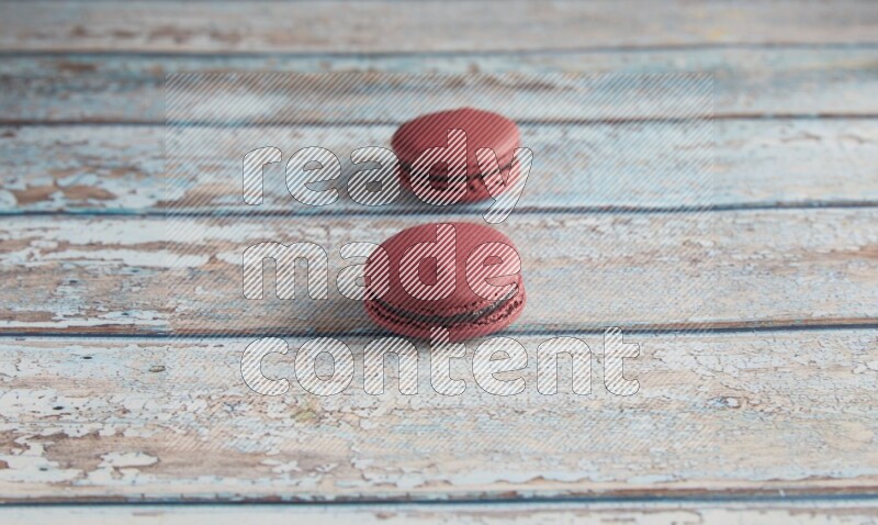 45º Shot of two Red Cherry macarons on light blue wooden background