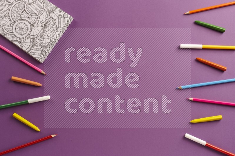 A coloring book with coloring pens on purple background