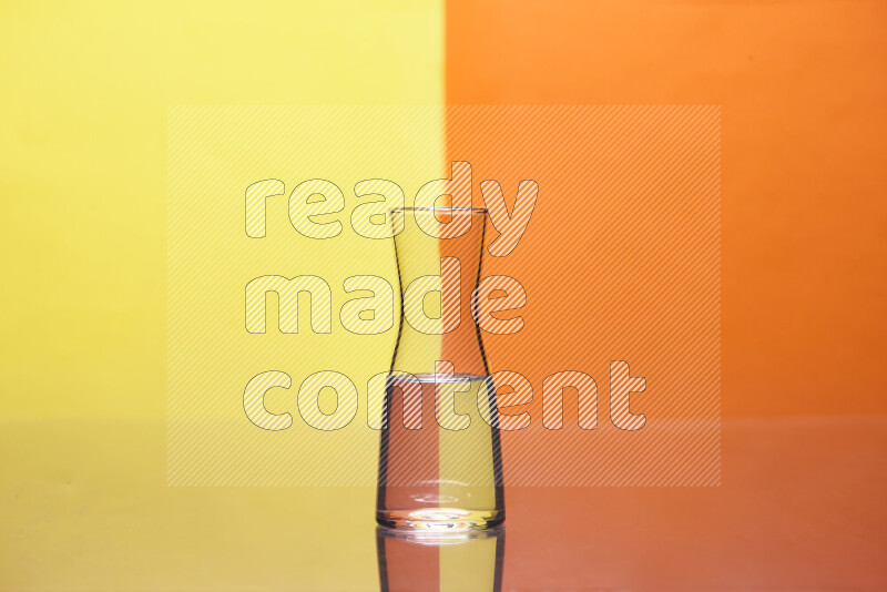 The image features a clear glassware filled with water, set against yellow and orange background