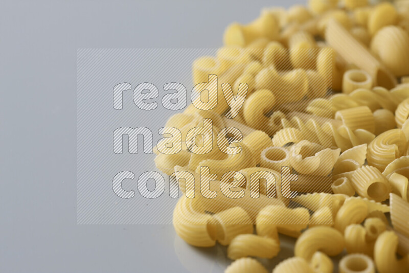 Different pasta types on light blue background