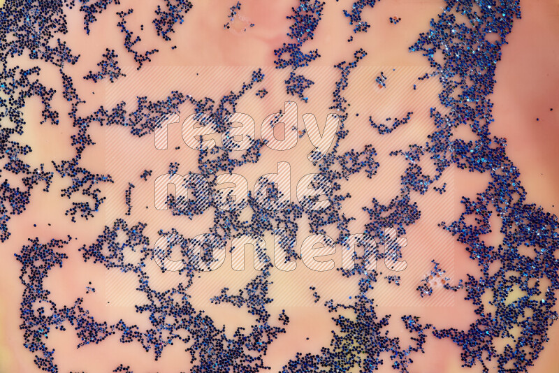 لقطة مقربة لبريق أزرق متلألئ منتشر على خلفية من اللون الأصفر والأحمر في حركات دائرية