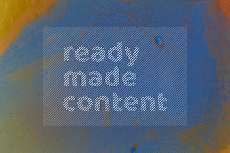 The image captures a dramatic splatter of blue paint over a orange backdrop