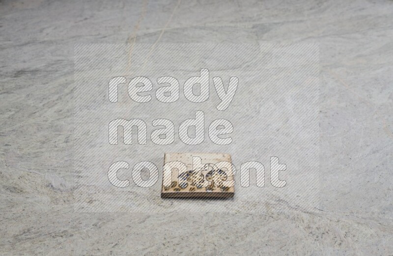 Top view shot of a pottery coaster\ tile on beige marble flooring