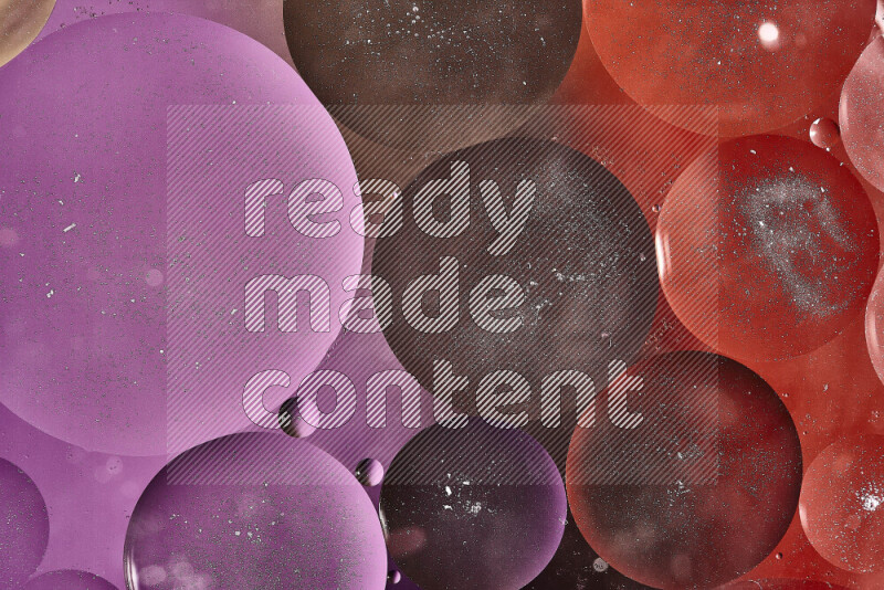 لقطات مقربة لفقاعات من الزيت على سطح الماء باللون البني والبرتقالي والأرجواني