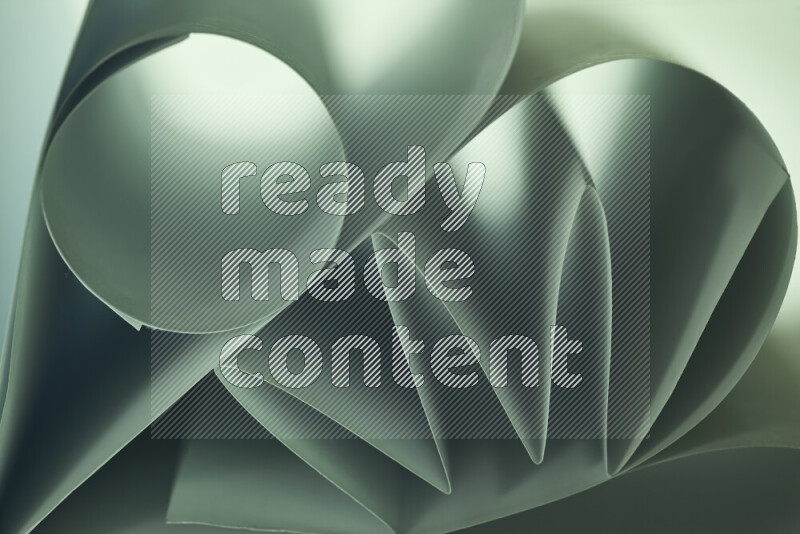 An artistic display of paper folds creating a harmonious blend of geometric shapes, highlighted by soft lighting in green tones