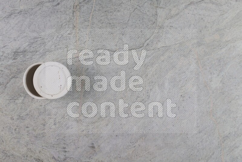 كأس فخاري متعدد الألوان على خلفية من الرخام الرمادي