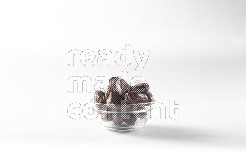Dates in a glass bowl on white background