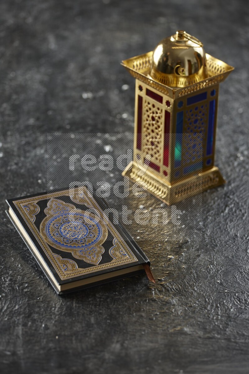 A golden lantern with different drinks, dates, nuts, prayer beads and quran on textured black background