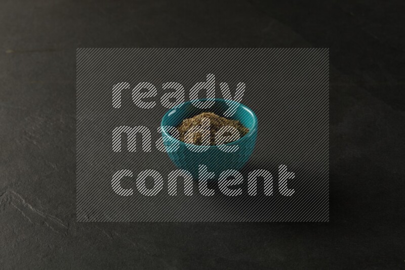 turquoise pottery round sauce bowl filled with herbs on grey textured countertop