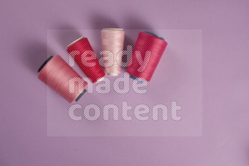 A pink and purple collection of sewing and tailoring tools arranged on a purple background