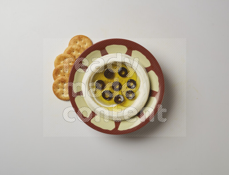 Lebnah garnished with sliced olives in a traditional plate on a white background