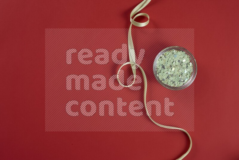 مجموعة من أدوات الخياطة والتفصيل خضراء وحمراء اللون على خلفية حمراء