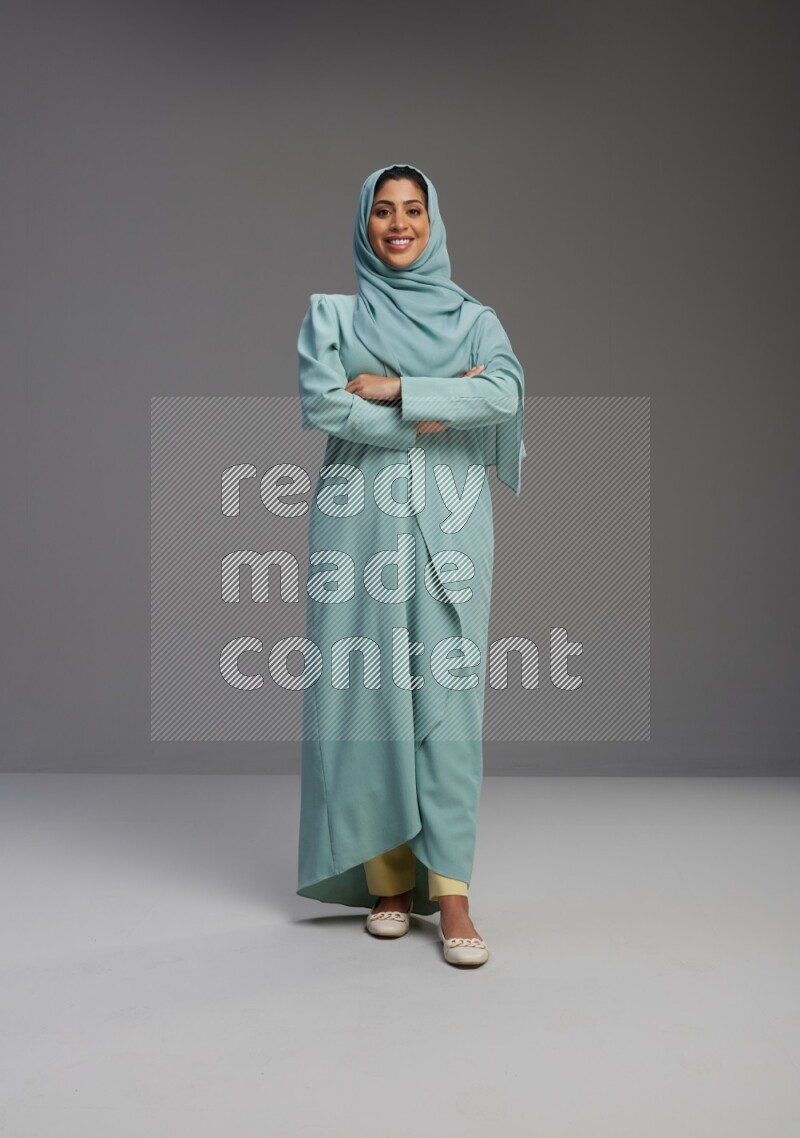 Saudi Woman wearing Abaya standing with crossed arms on Gray background