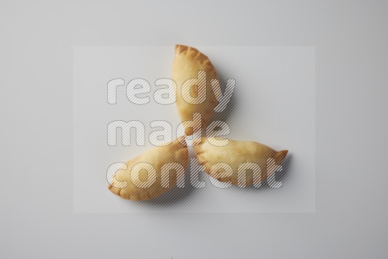 Three fried sambosa from a top angle on a white background