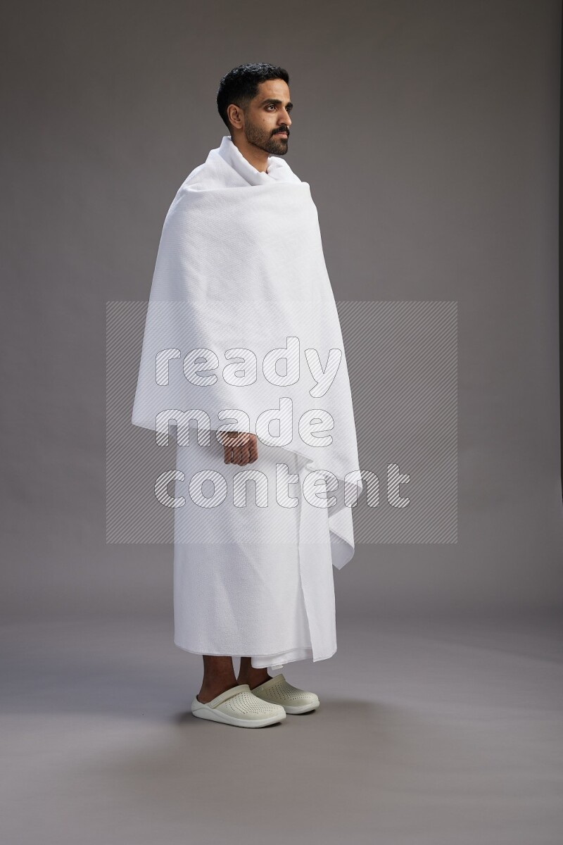 A man wearing Ehram Standing Interacting with the camera on gray background