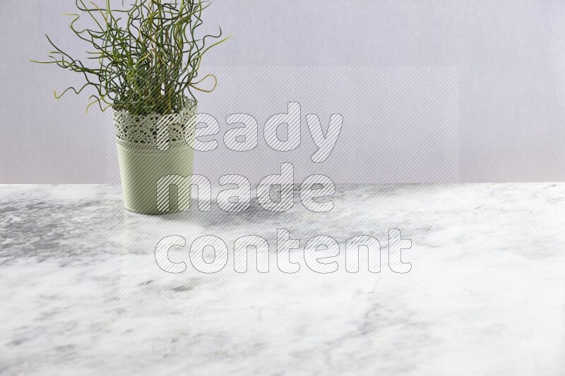 Artificial plant in green decorative pot on grey marble background