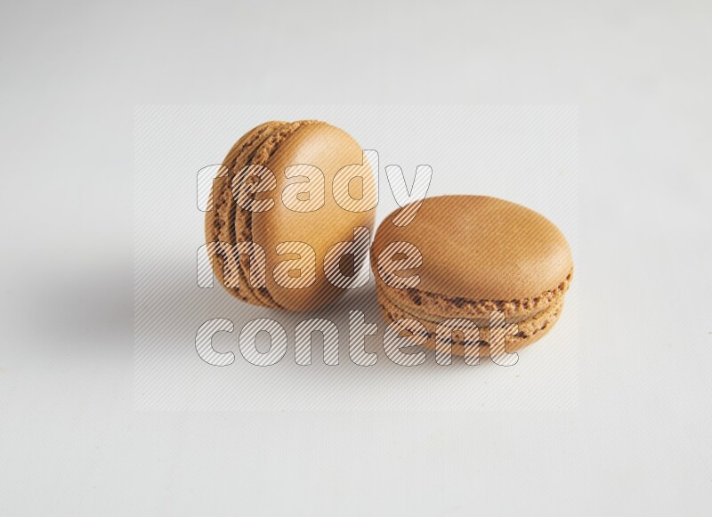 45º Shot of two Brown Maple Taffy macarons on white background
