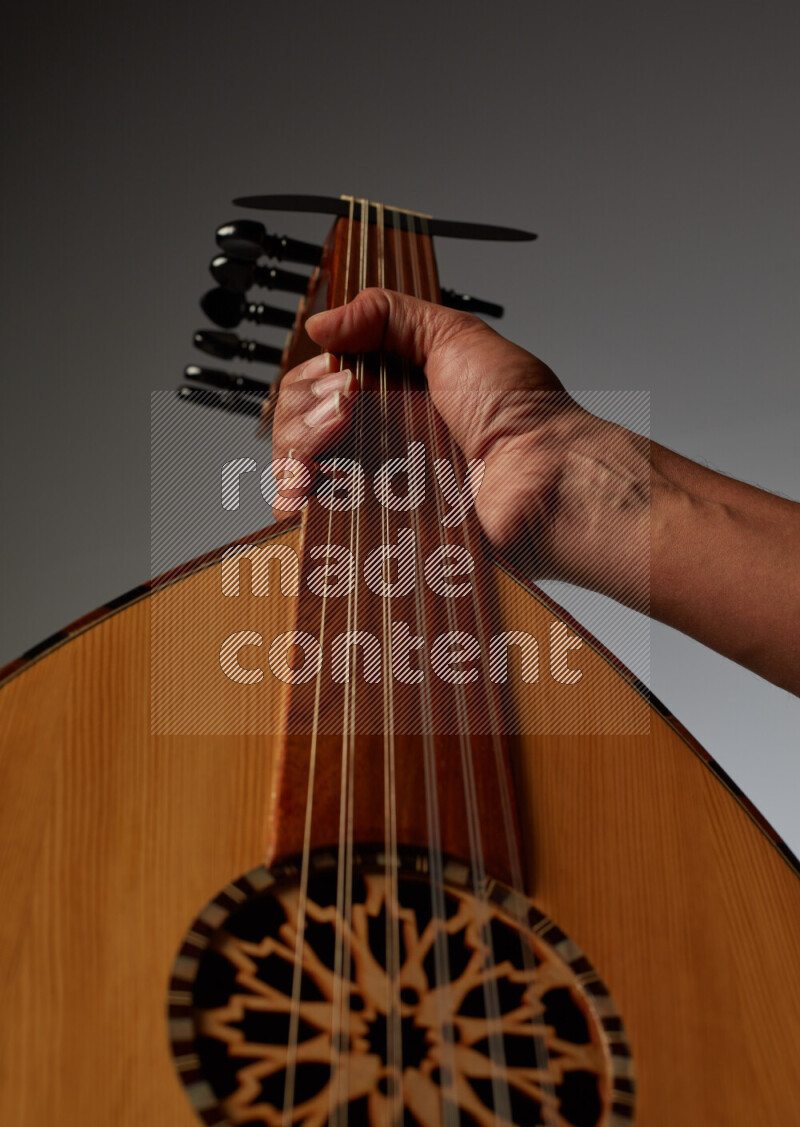 a hand intracting with a wooden brown Oud