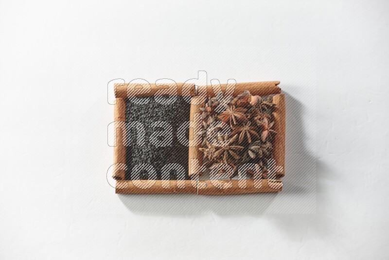2 squares of cinnamon sticks full of black seeds and star anise on white flooring