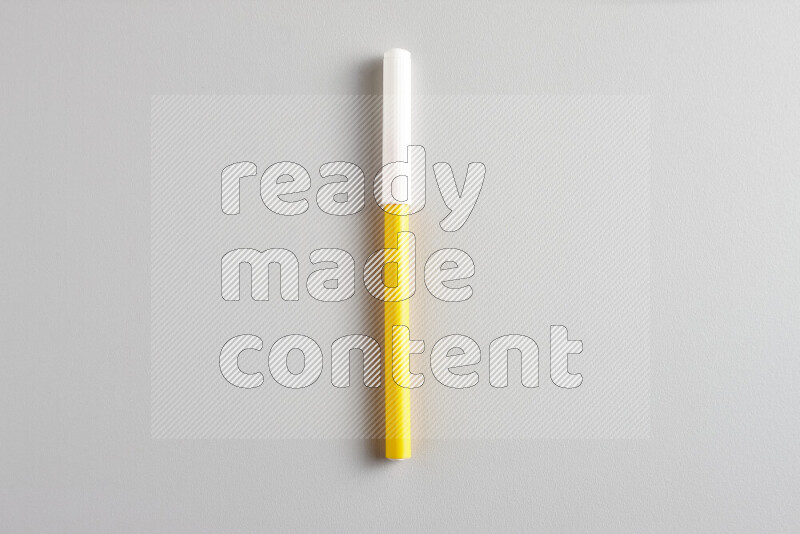 A close-up showing a single coloring pen with a cap on grey background