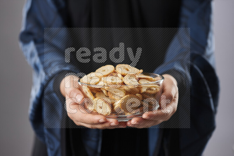 Woman in abaya holding different kinds of snacks in different positions