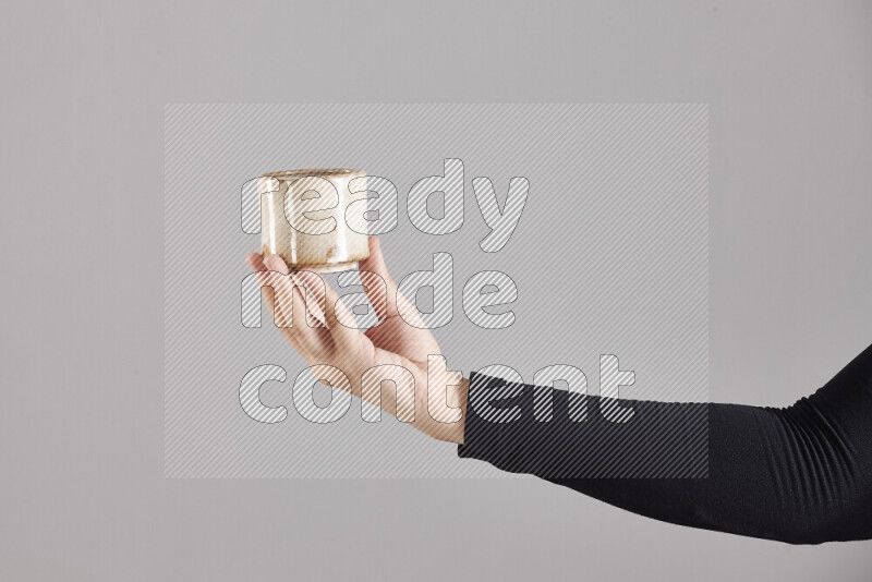 A woman in black abaya holding different pottery essentials in different positions