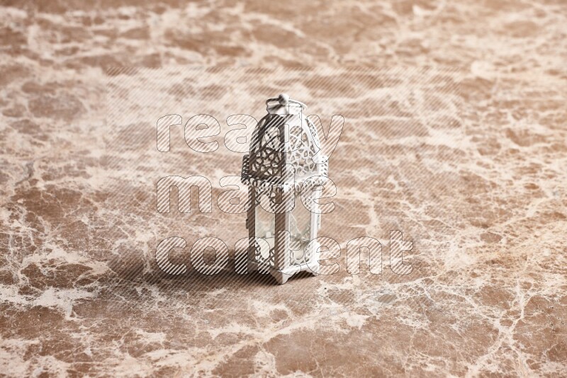 A candle lantern on beige marble background